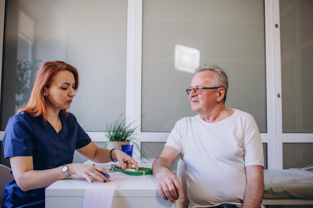 Een senior man wordt onderzocht door een jonge vrouwelijke arts in een ziekenhuis