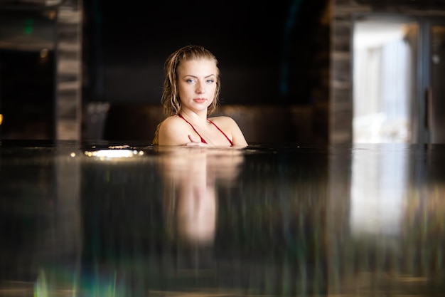 Een serene vrouw ontspant zich in het binnenzwembad.