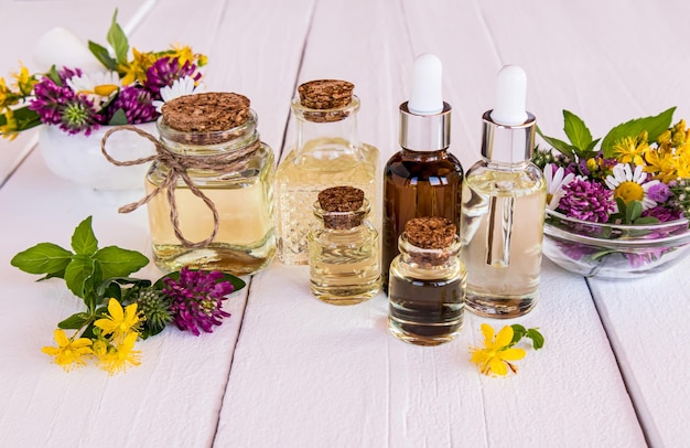 Foto een set cosmetische producten van natuurlijke ingrediënten in verschillende flessen biologische kruidenolie etherische olie en serum witte houten achtergrond