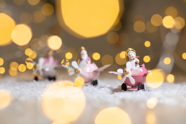 Een set decoratieve beeldjes met kerstthema, Kerstman herten en sneeuwpop in roze vliegtuigen met propeller,,