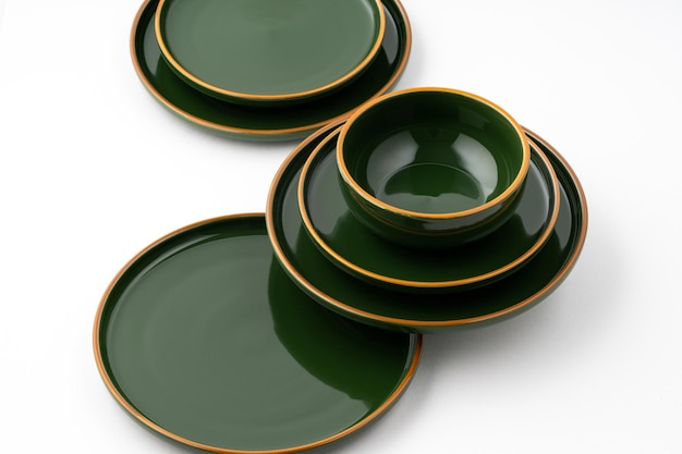 Een set groene keramische borden en kom op een witte achtergrond