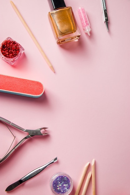 Een set hulpmiddelen voor manicure en nagelverzorging op een roze