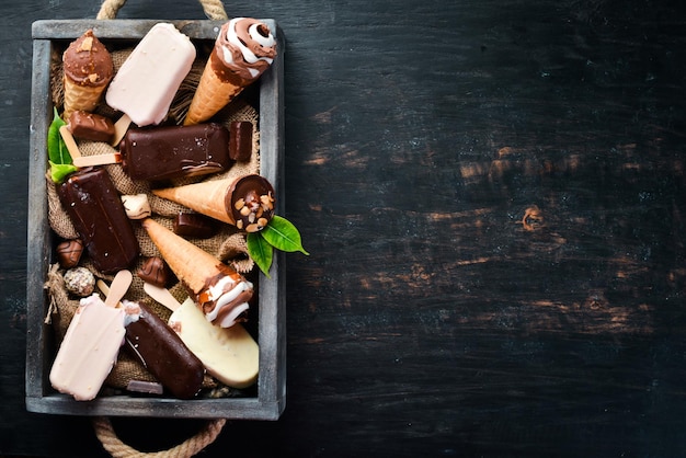 Een set ijs met chocolade noten en jam Op een zwarte achtergrond Bovenaanzicht Gratis kopieerruimte