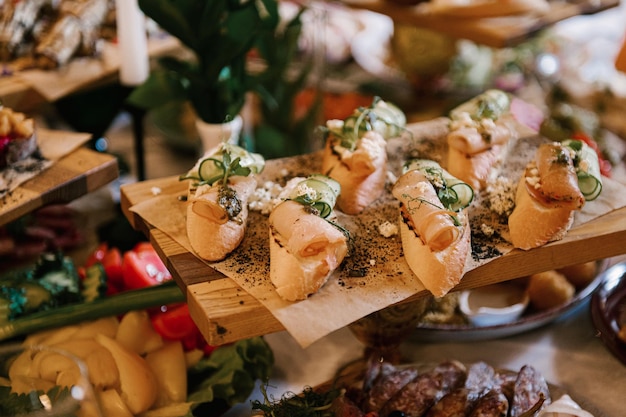 Een set Italiaanse hapjes voor een buffet Een verscheidenheid aan kazen, vleeswaren, bruschetta, gepekelde komkommers, tomaten op een houten ondergrond