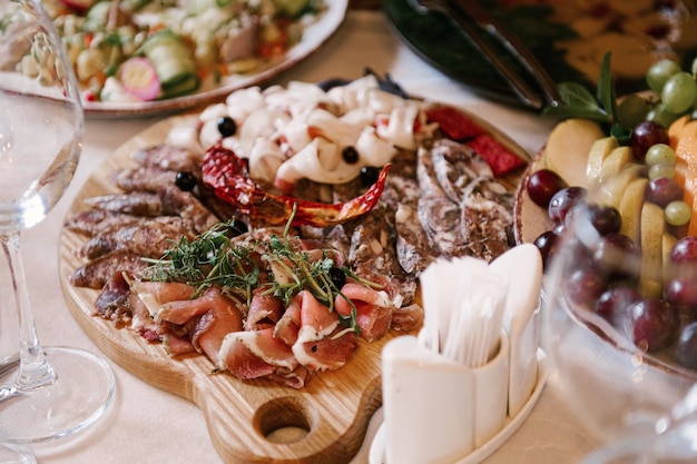Foto een set italiaanse hapjes voor een buffet een verscheidenheid aan kazen, vleeswaren, bruschetta, gepekelde komkommers, tomaten op een houten ondergrond