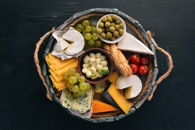 Een set kaas in een houten kist Parmezaanse kaas Mamasam Mozzarella Brie Feta Bovenaanzicht Op een houten achtergrond Vrije ruimte voor uw tekst