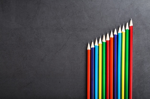 Een set kleurrijke potloden op een gestructureerde donkere achtergrond