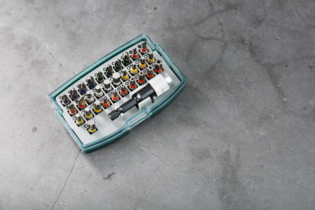 Een set metalen powerbits in een doos op een grijze achtergrond