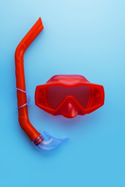 Een set rode zwemmasker en snorkel op een blauwe achtergrond