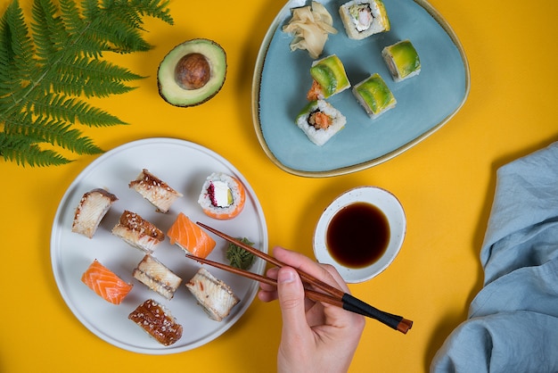 Een set sushi rolt ander type op een gele ruimte. Bovenaanzicht. Traditionele Aziatische gerechten