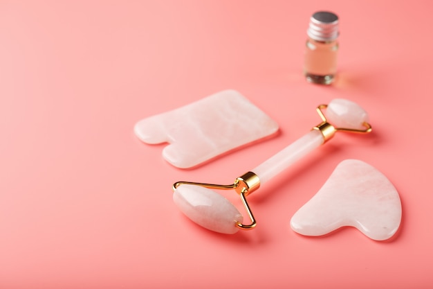 Een set tools voor gezichtsmassagetechniek Gua Sha gemaakt van natuurlijke rozenkwarts