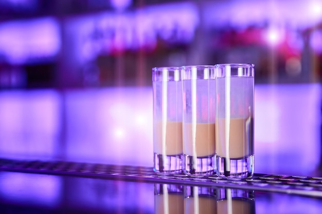 Een set tweekleurige alcoholshots op de bar van een nachtclub