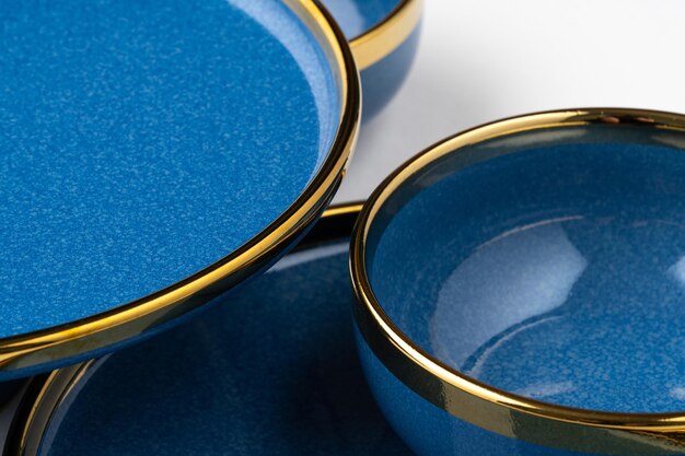 Een set van blauwe keramische platen en beker op een witte achtergrond Close-up