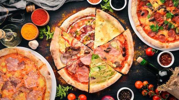 Een set van Italiaanse pizza Italiaanse keuken Op een zwarte houten achtergrond Gratis kopieerruimte Bovenaanzicht