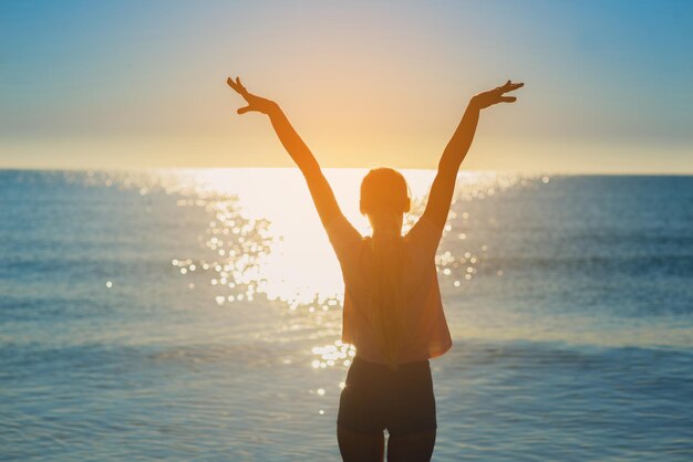 Een silhouet op de vrouw tegen de zonsondergang op de oceaan of de zee