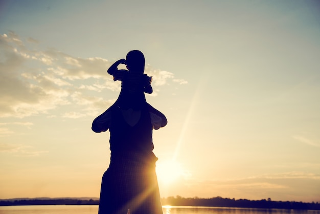 Een silhouet van een gelukkige jonge moeder harmonieuze familie buitenshuis.