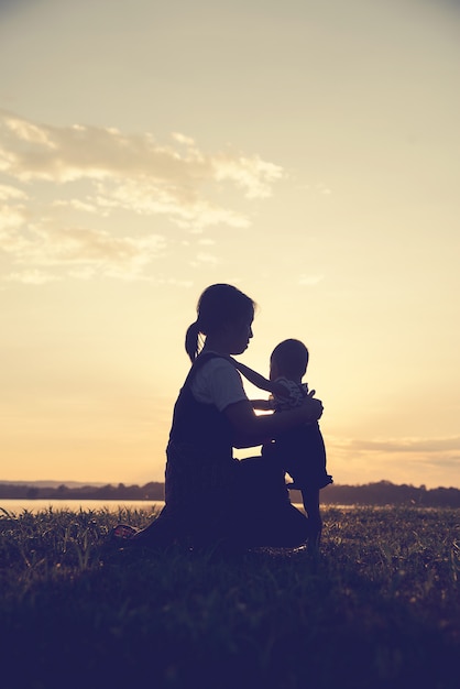 Een silhouet van een gelukkige jonge moeder harmonieuze familie buitenshuis.