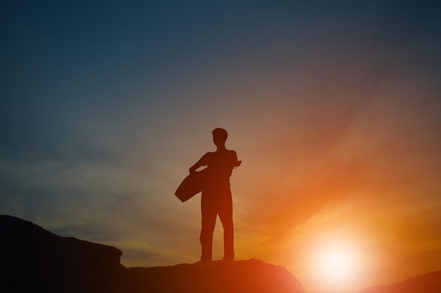 Een silhouet van een man met een gitaar hand in hand