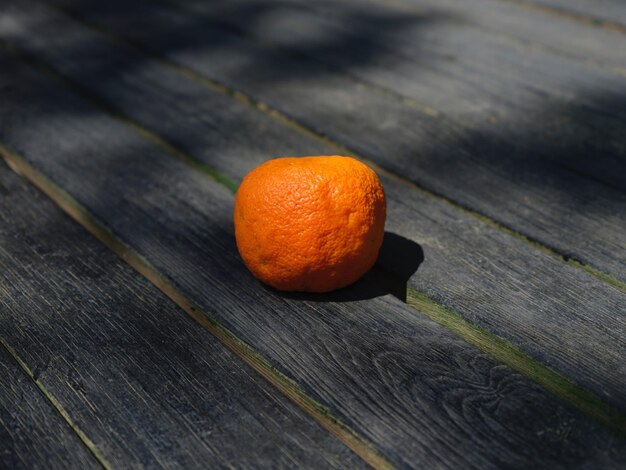 Foto een sinaasappel op een grijze houten tafelfoto