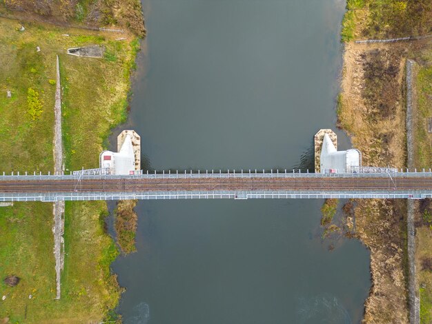 Een singletrack spoorbrug over de rivier in de stad Bovenaanzicht van de brug in een prachtig groen park Een drone vliegen over een spoorbrug in de mist Herfstlandschap