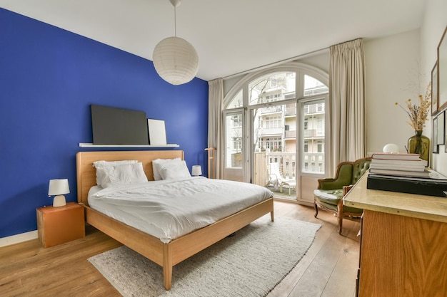 Een slaapkamer met een bed en een blauwe accentmuur