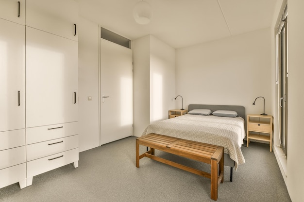 Een slaapkamer met een bed en een houten bank