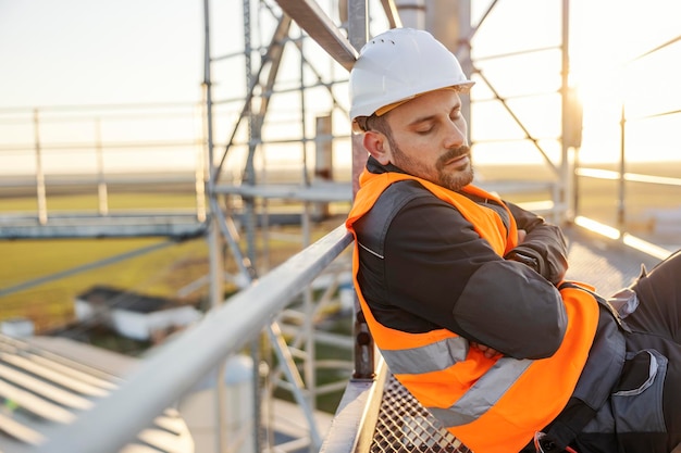 Een slaperige werker op hoogte slaapt op een metalen constructie