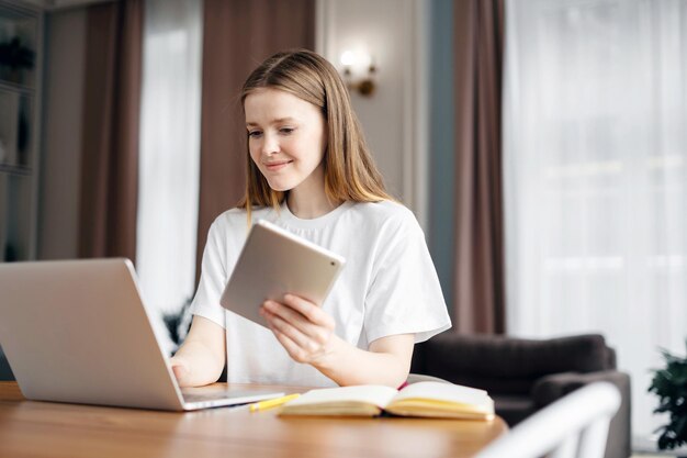 Een slimme vrouwelijke student freelancer online training onderwijs thuis werkplek maakt gebruik van een laptop