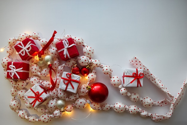 een slinger van witte ballen in een rode stip rode geschenkdozen witte en rode ballen op een witte