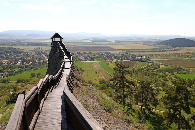 Een smalle loopbrug langs een landschap met een berg op de achtergrond