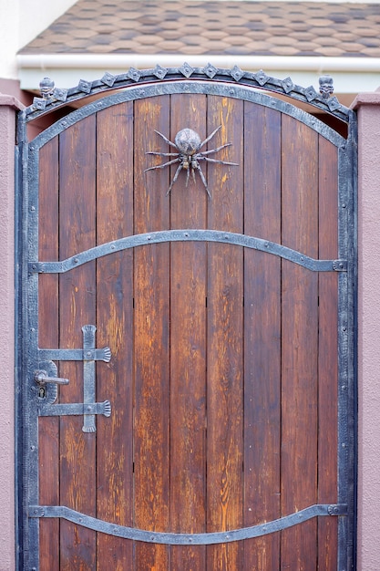Een smeedijzeren spin siert de poort. Halloween woondecoratie