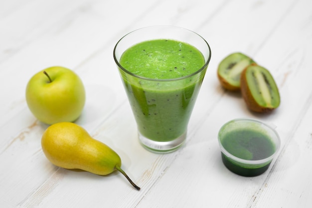 Een smoothie gemaakt van witte graspeer, appel en kiwi Ontgifting Tarwe