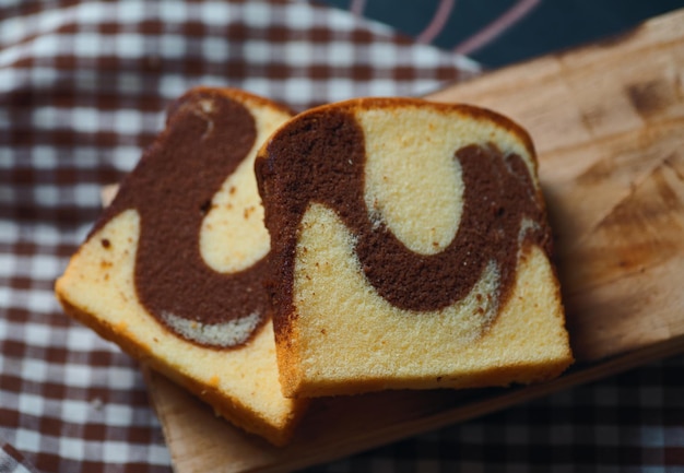 Een sneetje kaneelswirlbrood op een houten snijplank.