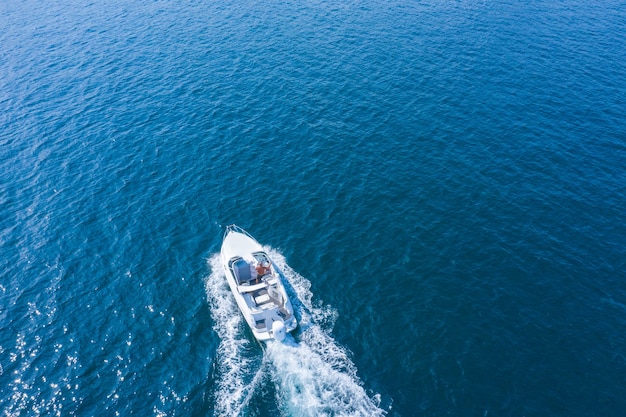 Een snelle boot of jacht manoeuvreert op het oppervlak van de zee of oceaan. Luchtfoto.