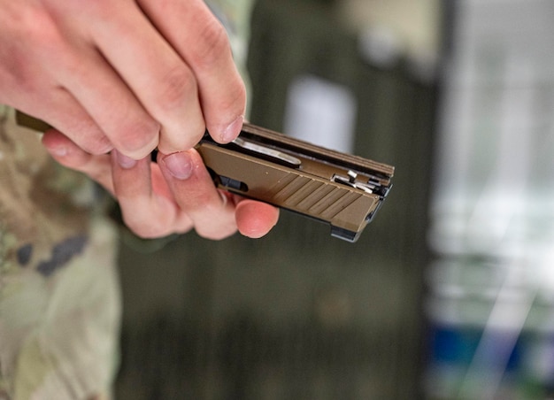 Een soldaat houdt een klein geweer in zijn hand.