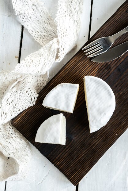 Een soort Brie-kaas. Camembert kaas. Verse brie kaas en plak op een houten bord. Italiaans