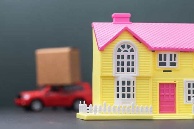 Een speelgoedhuis en een auto met een lading op het dak