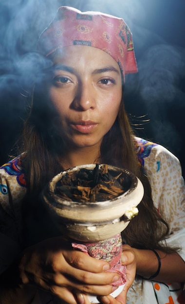 Foto een spirituele vrouw die brandende tabak en wierook vasthoudt