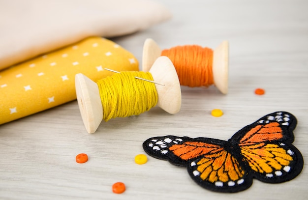 een spoel geel en oranje draad en een katoenen doek op tafel