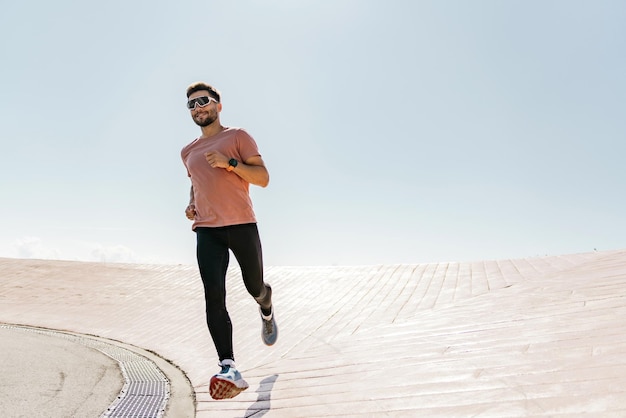 Een sportieve persoon die in sportschoenen loopt en een slim fitnesshorloge aan zijn arm draagt, gebruikt hardlopen voor training.