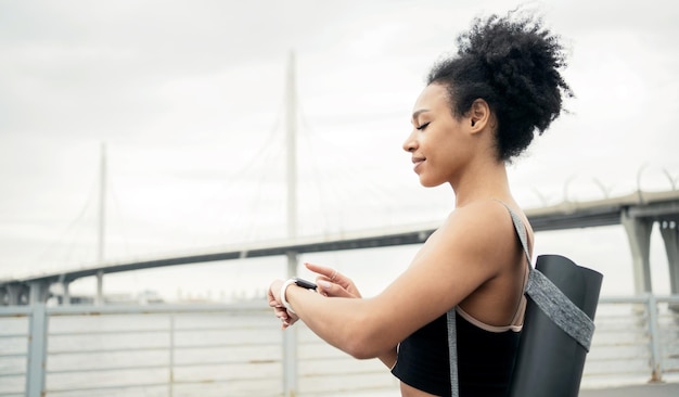 Een sportieve vrouw traint buiten met een fitnesshorloge