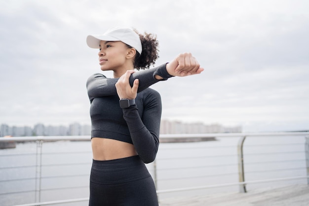 Een sportieve vrouwelijke hardloper gebruikt een fitnesshorloge om te trainen