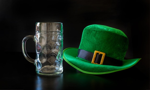 Een St. Patrick daghoed van een kabouter en een glas bier op de zwarte