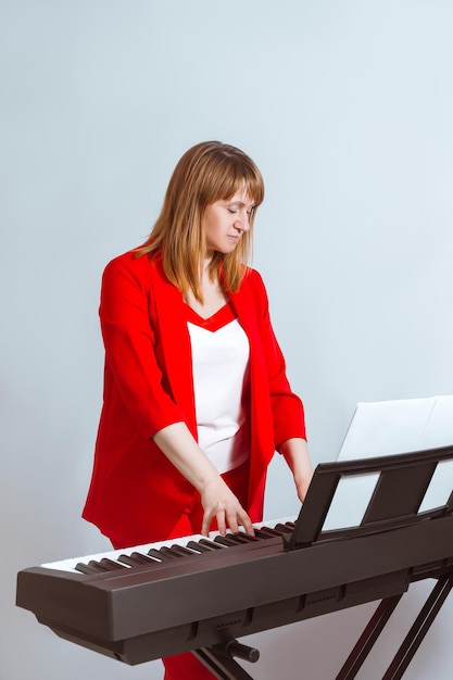 Een staand meisje speelt een elektronische piano