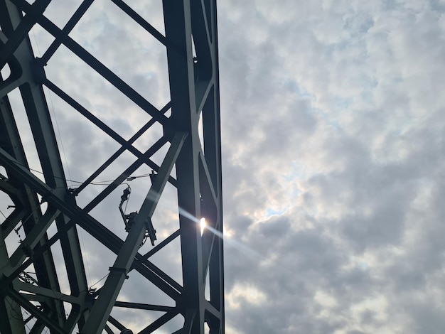 Een standbeeld staat voor een bewolkte hemel waar de zon doorheen schijnt.