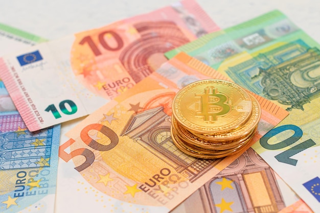 Een stapel bitcoinmunten op de eurobankbiljetten