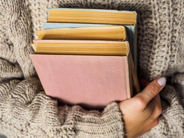 Een stapel boeken in handen van de vrouw