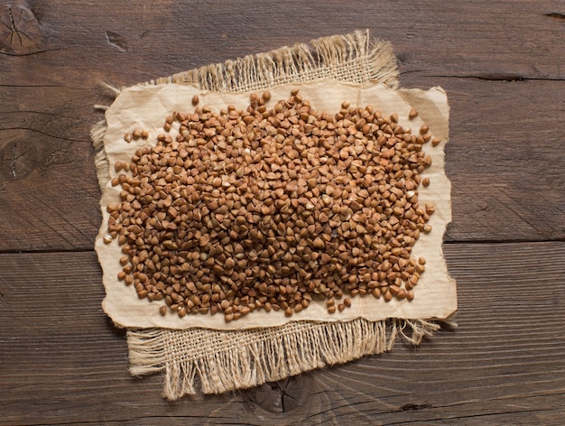 Een stapel boekweit op een houten tafelblad bekijken