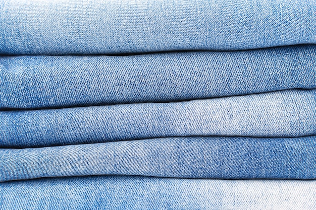 Foto een stapel gevouwen blauwe jeans close-up denim textuur achtergrond, een verscheidenheid aan comfortabele casual broek en kleding