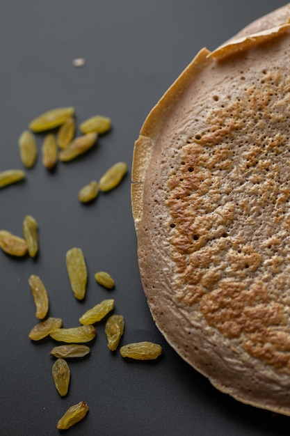 Een stapel havermout-bananenpannenkoekjes met plakjes verse bananen, walnoten en honing bovenop met kopje thee op een witte houten achtergrond Een gezond ontbijt Kopieer ruimte